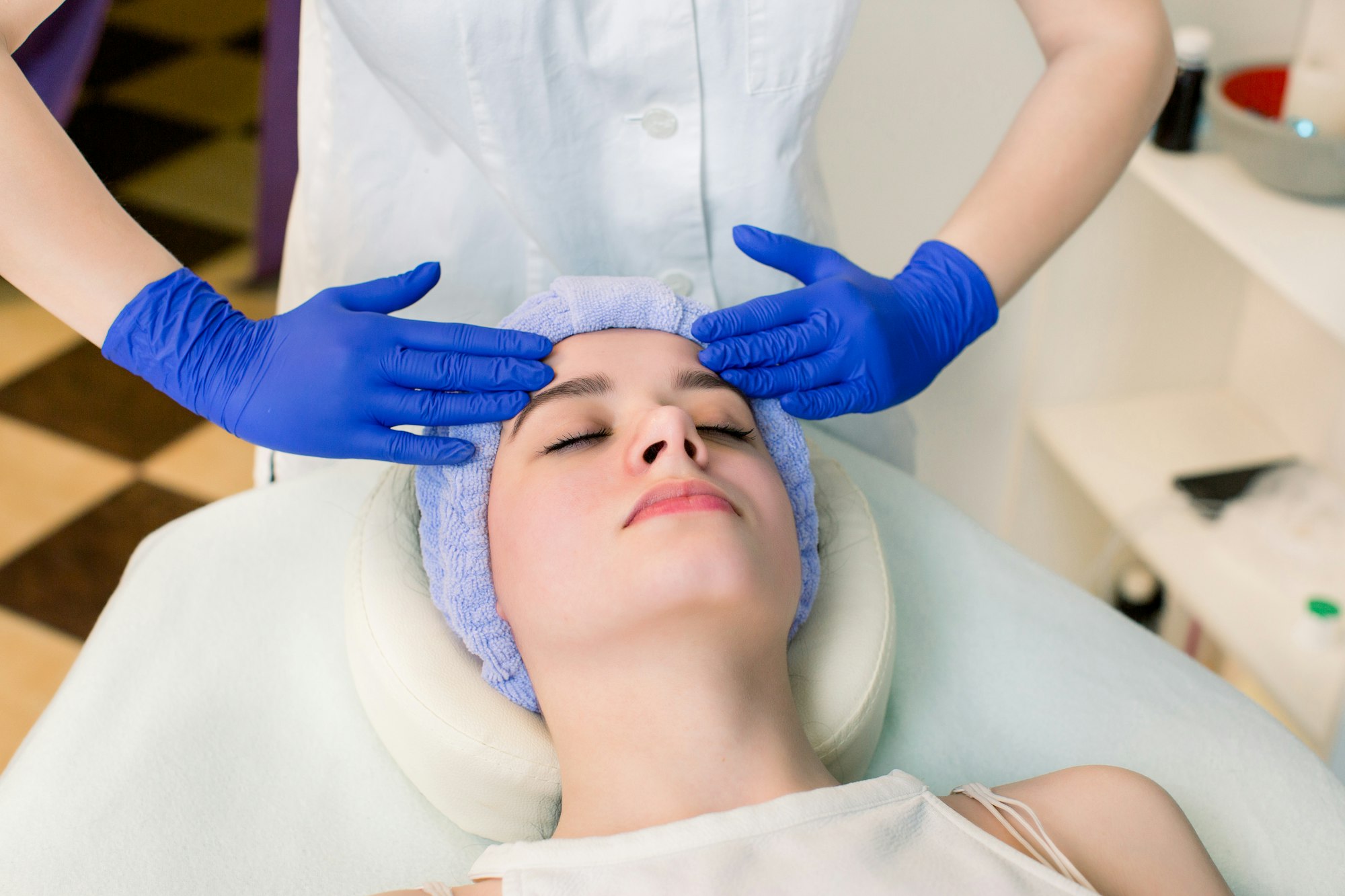 In beauty center. Beautiful good-looking woman enjoying face massage in beauty center