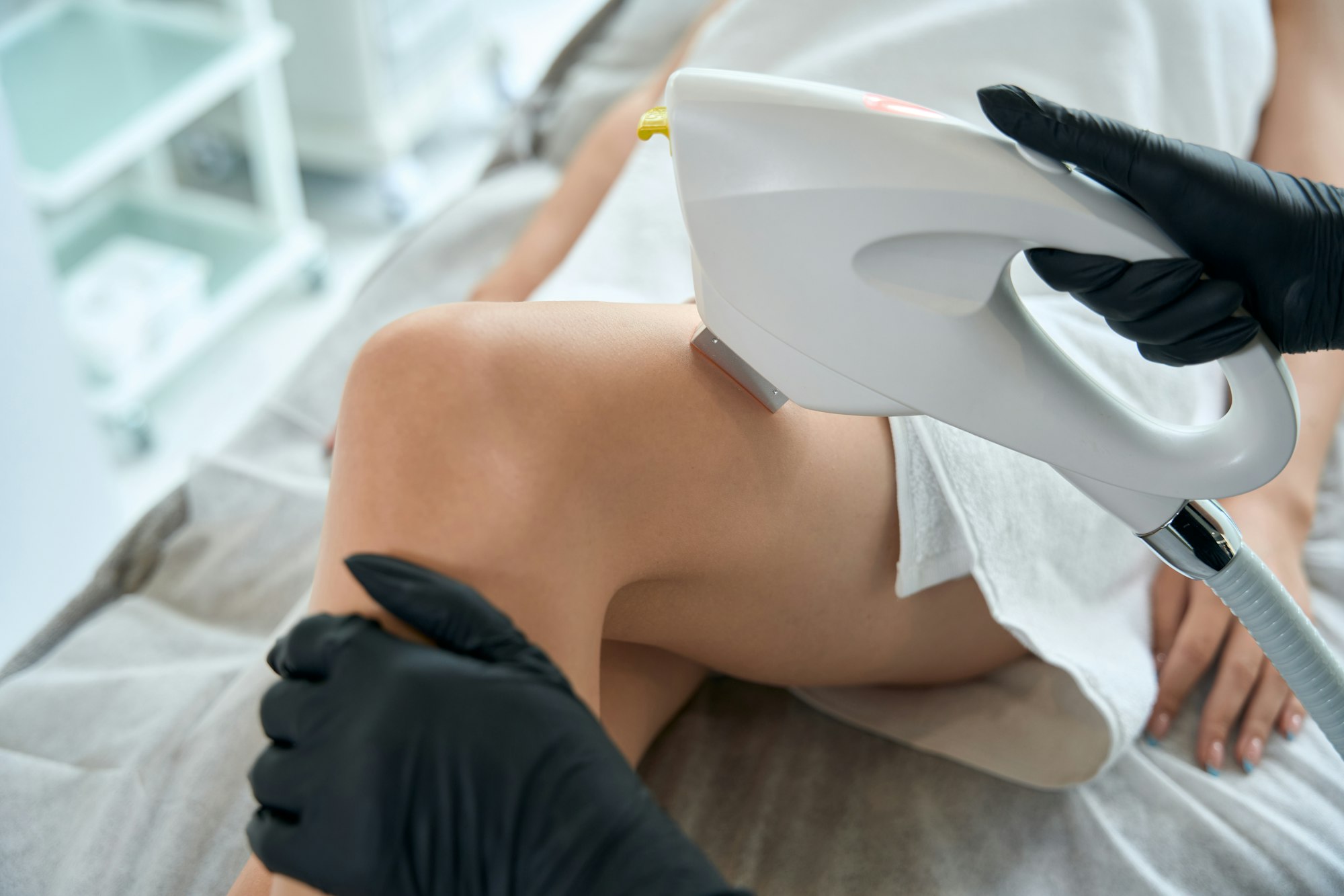 Dermatologist on leg laser hair removal procedure